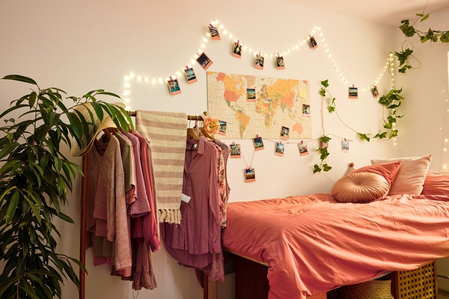 Chambre confortable avec lit bien fait, oreillers et plaid vert. Des œuvres d'art au-dessus du lit avec des bandes Command. Un bureau, une chaise et des photos avec crochets Command ajoutent du charme. Plantes pour la chaleur.
